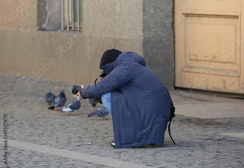 Photographer in a long coat on the street at work, Bolshaya Morskaya Street, St. Petersburg, Russia, March 2022 photo