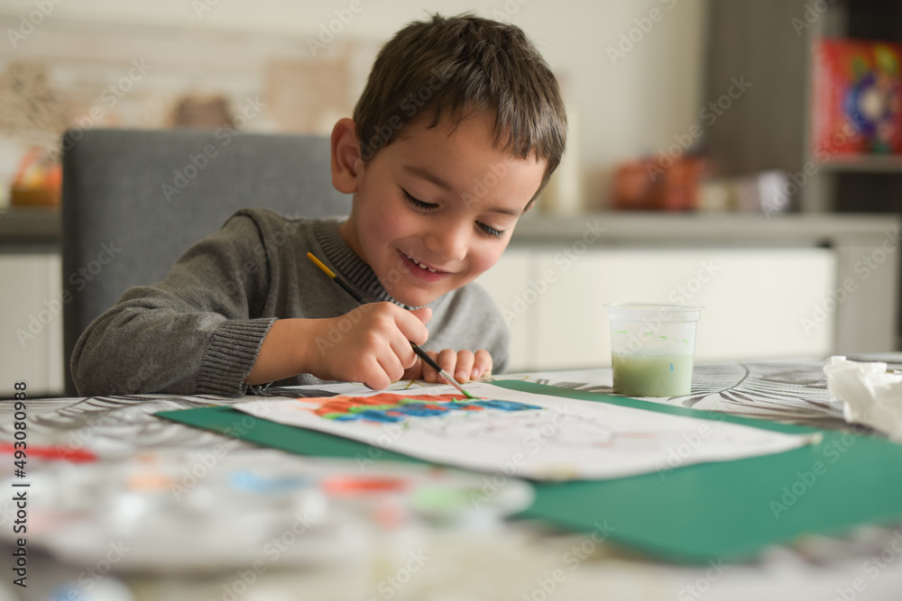 young caucasian boy doing painting at home with pleasure young caucasian boy doing painting at home with pleasure
