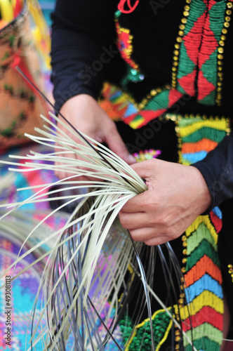 Hands of woman showing weaving action of traditional bamboo basket from the Kadazan Dusun Murut ethnic of Sabah Borneo, Malaysia. photo