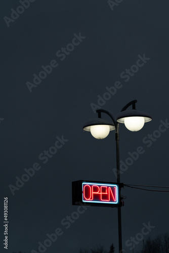 OPEN light sign with red neon text. Dark background.