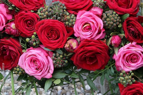 Rote Rosen und Efeu-Beeren in einem Gesteck  Floristik  Blumenarrangement  Dekoration
