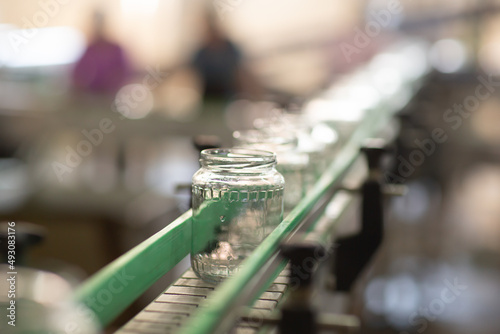 Empty glass jars ready for canning. Food industry background. Preservation of vegetables. An industrial line for processing and preserving.