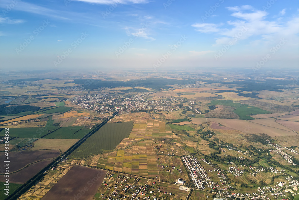 Aerial view of farm fields and distant scattered houses in rural area