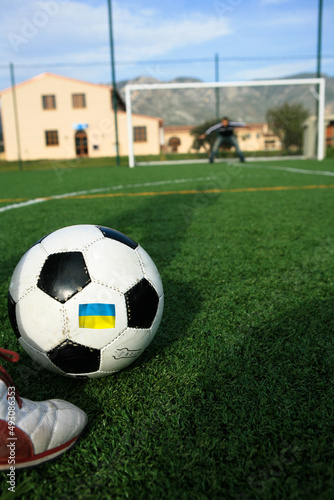 pallone da calcio  con. sopra la bandiera con i  colori dell Ucraina mentre si calcia un rigore