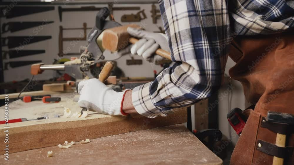 Skilled carpenter carving wood with hammer and chisel. High quality 4k footage