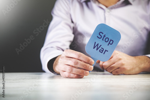 man holding stop war text