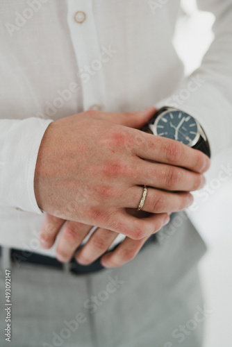 Wedding fashion for men. Closeup of caucasian man put on his watch.