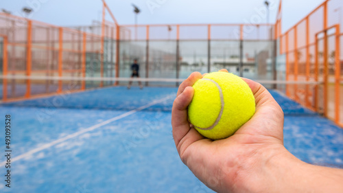 Monitor holding paddle tennis ball for teaching padel. Class on outdoor court. © REC Stock Footage