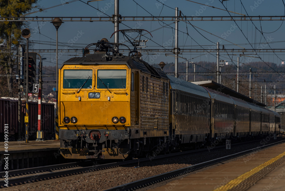 Zabreh station with yellow passenger and cargo trains in sunny day