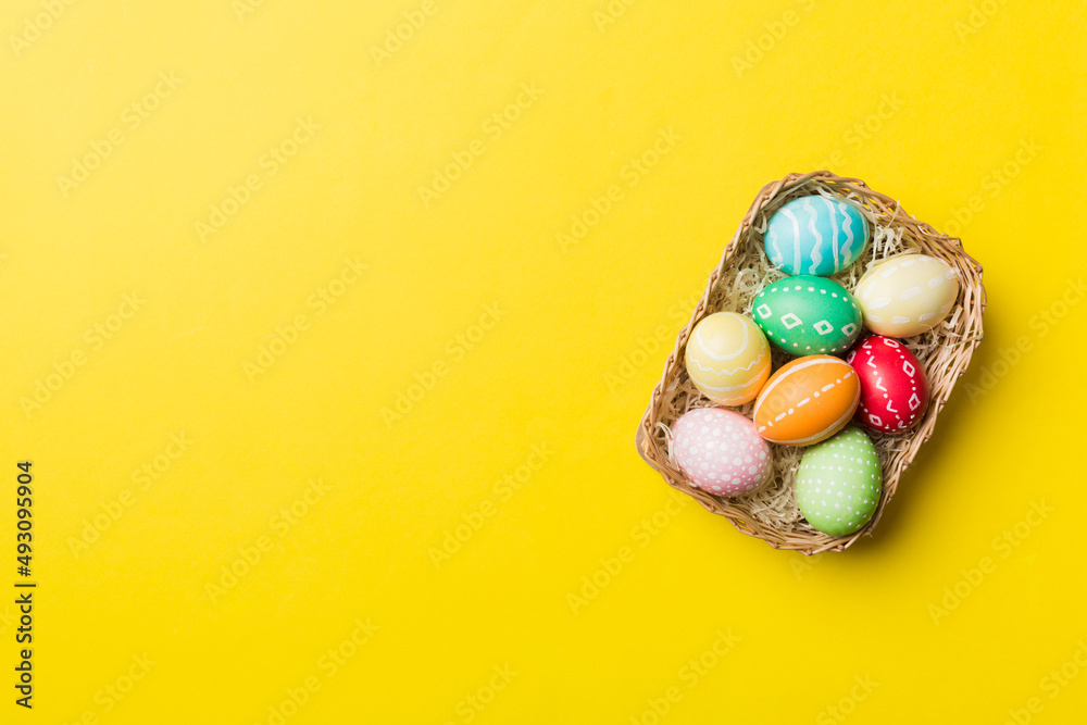 Multi colors Easter eggs in the woven basket on colored background . Pastel color Easter eggs. holiday concept with copy space Multi colors Easter eggs in the woven basket on colored background . Pastel color Easter eggs. holiday concept with copy space