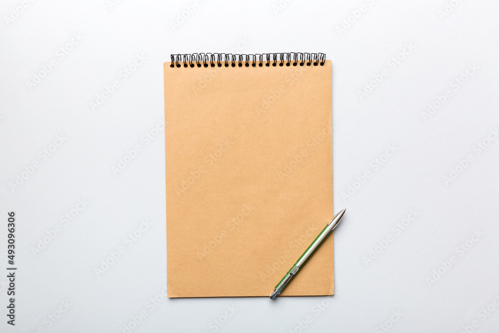 school brown notebook on a colored background, spiral craft notepad on a table Top view school brown notebook on a colored background, spiral craft notepad on a table Top view