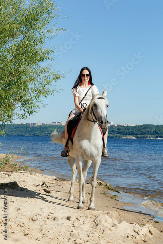 a girl on a horse on the river bank