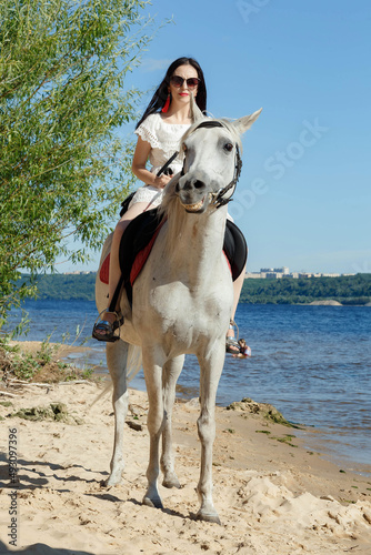 a girl on a horse on the river bank