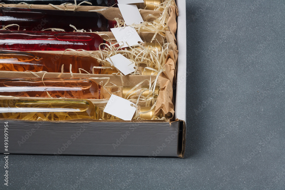 Fototapeta premium Assortment of 250 ml no label bottles of red, pink, white wine in box. Set of alcohol drinks for present or celebration. Close up, copy space