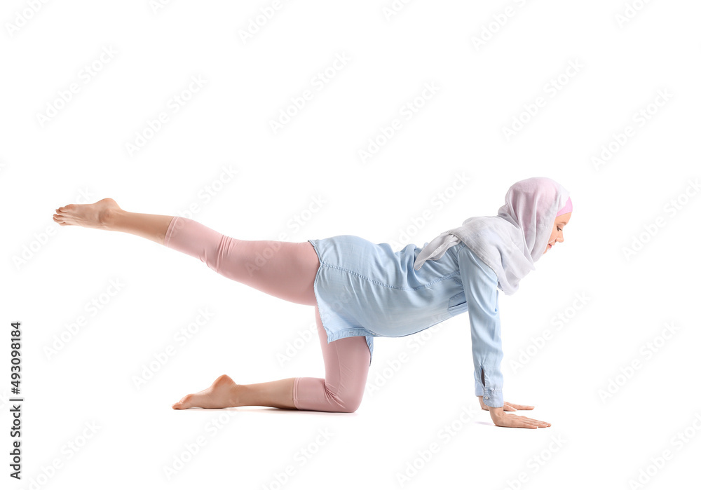 Pregnant Muslim woman doing yoga on white background