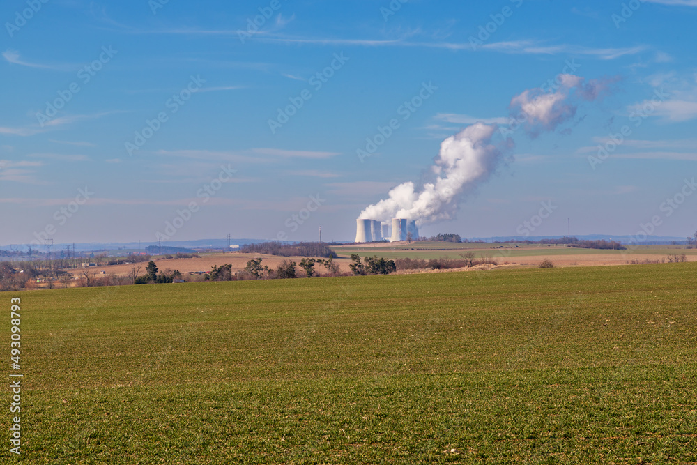 Dukovany Nuclear Power Plant in the Czech Republic, Europe. Smoke cooling towers. There are clouds in the sky. In the background the nature of the Highlands. Dukovany Nuclear Power Plant in the Czech Republic, Europe. Smoke cooling towers. There are clouds in the sky. In the background the nature of the Highlands.