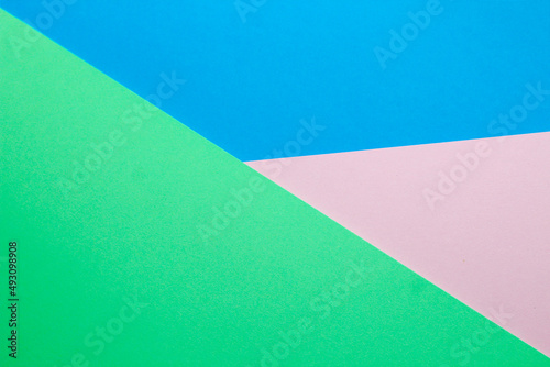 Abstract background with colored paper blue with pink and green color.