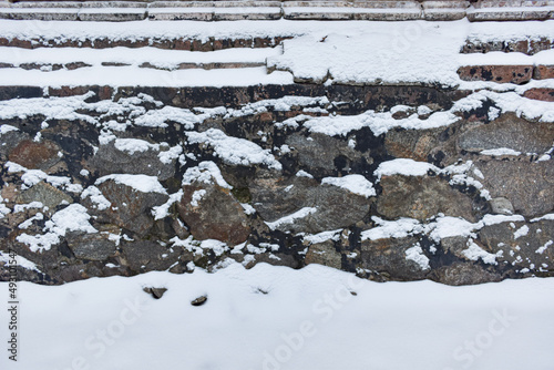 Stone wall covered by snow