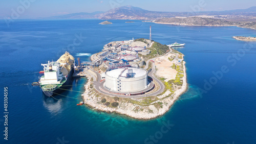 Aerial drone photo of LNG (Liquified Natural Gas) tanker anchored in small LNG industrial islet of Revithoussa equipped with tanks for storage, Salamina, Greece photo