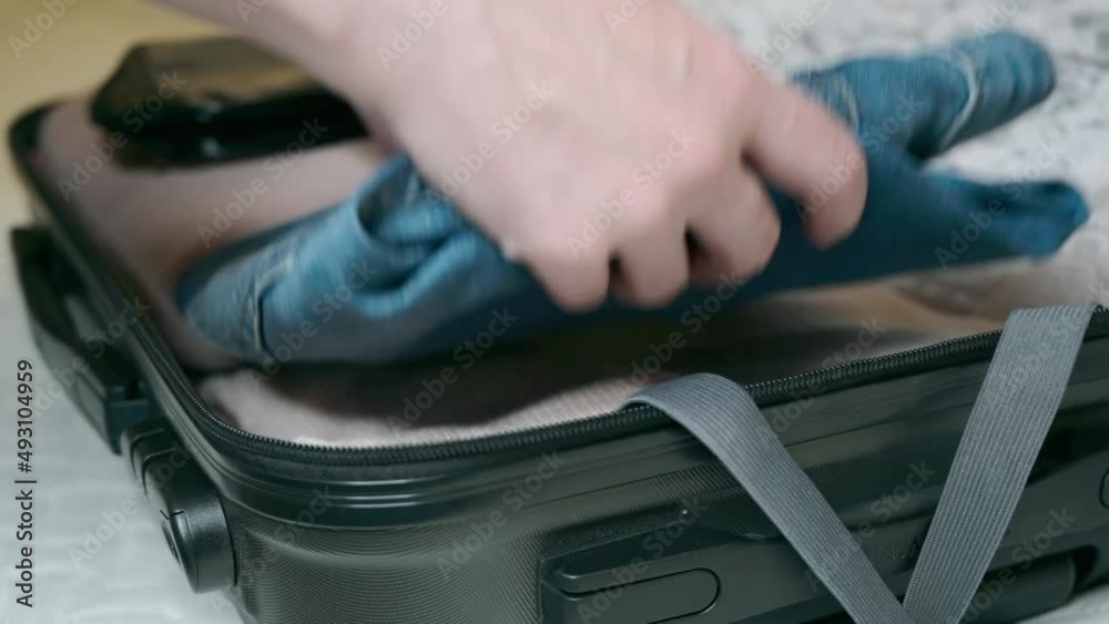 Woman packing a suitcase for a travel or weekend trip. Female hands put a clothes and zip up a suitcase. Woman packing a suitcase for a travel or weekend trip. Female hands put a clothes and zip up a suitcase.
