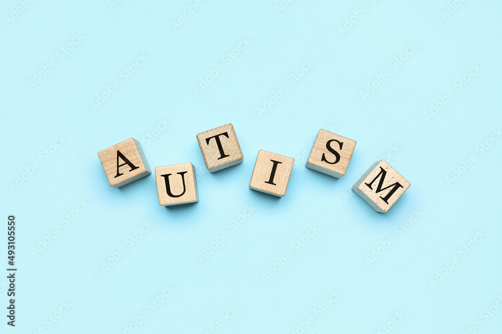 Wooden cubes with word AUTISM on blue background Wooden cubes with word AUTISM on blue background