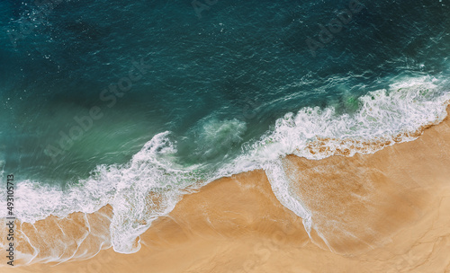 Wild beach with a beautiful clear ocean. Ocean from a bird's eye view. Top view of the tropical beach. Paradise island. Lonely sandy beach with beautiful waves. Beaches of Indonesia. Copy space