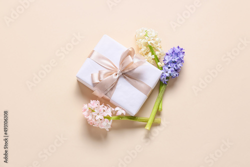 Beautiful gift box and hyacinth flowers on color background © Pixel-Shot