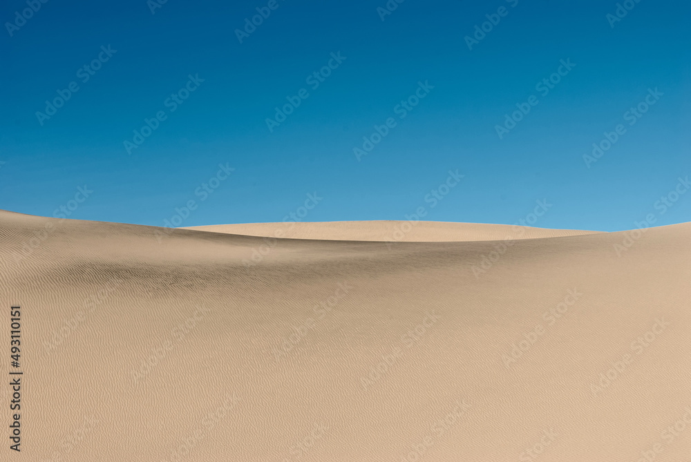 Desert landscape. Sand dunes under the blue sky. Traces of wind on the surface of the sand dune. Desert landscape. Sand dunes under the blue sky. Traces of wind on the surface of the sand dune.