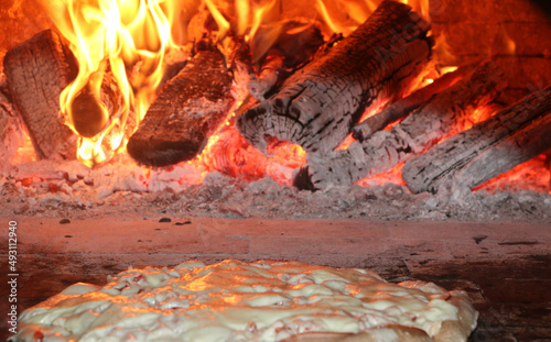 Pizza em um forno a lenha em chamas