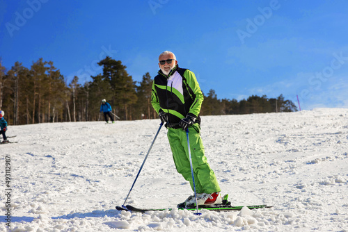 Portrait of Older man skiing and enjoy on mountain covered with snow.