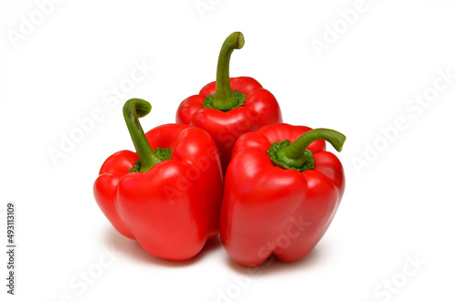 three red sweet peppers isolated on white background