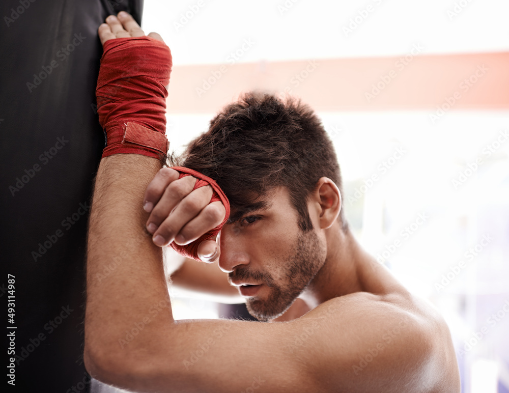 Fit and fierce. Portrait of a muscular young boxing standing in a gym. Fit and fierce. Portrait of a muscular young boxing standing in a gym.