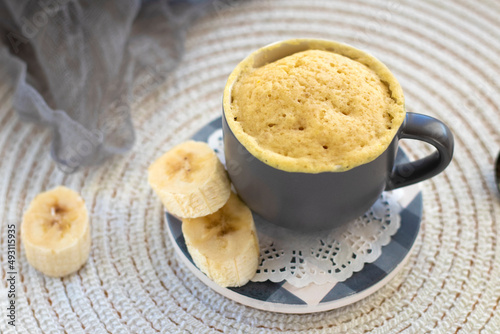 selective focus. homemade Portioned Banana bread mugcake in small mugs. Easy sweet baking in the microwave idea, With fresh bananas, nuts. Muffin with banana slices cooked in a mug. copy space. 