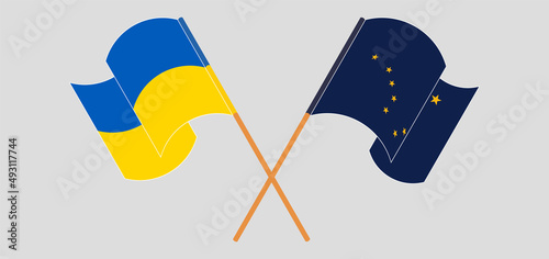 Crossed and waving flags of Ukraine and the State of Alaska