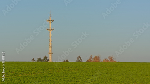 Farmland with radio tower of an airport in the flemish countryside photo