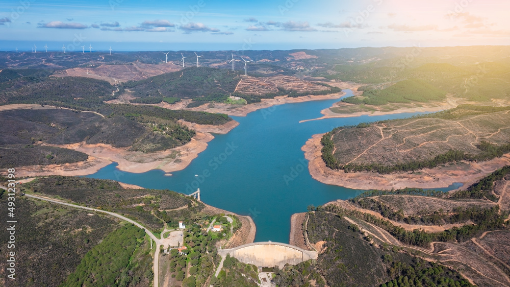 Aerial. Photo from sky, dams filled with water Bravura Portimao. in background, wind generators for clean ecological electricity. Sunny day