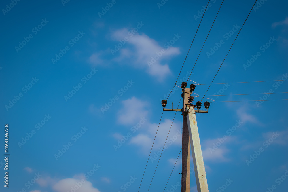 Concrete pole and cables of an old electric power transmission line on blue sky background Concrete pole and cables of an old electric power transmission line on blue sky background
