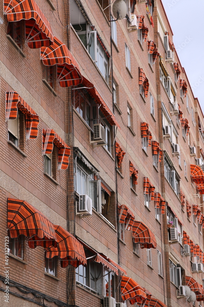 The apartment has the same awnings on the windows to form a pattern.