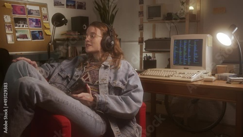 Girl listening to music and singing with a classic walkman player in her bedroom.