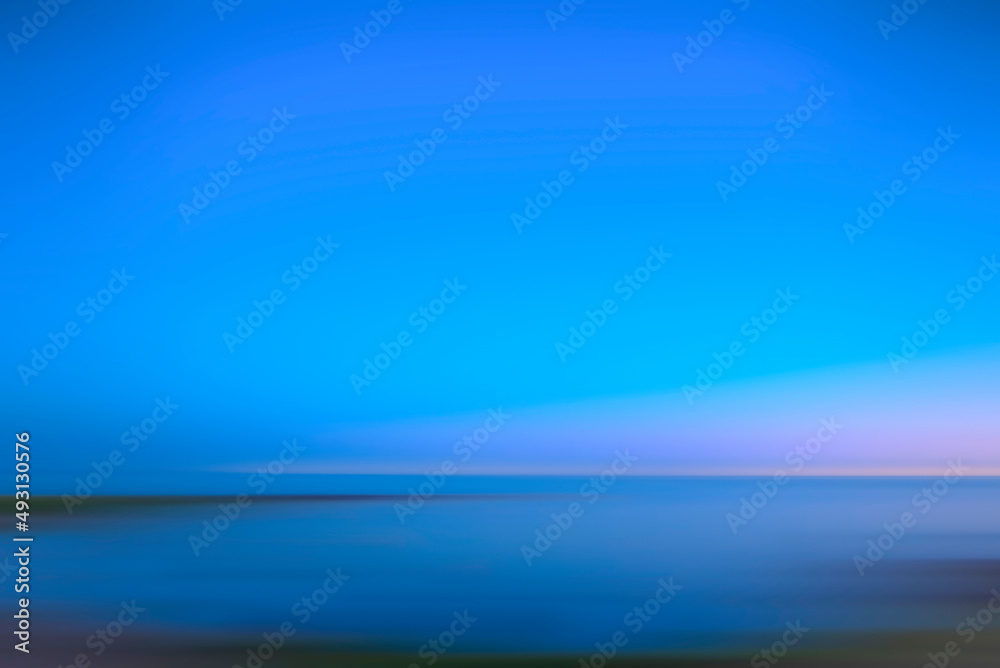 Peaceful beautiful abstract outdoor photograph from beach of horizon with ocean and sky during blue hour with copy space