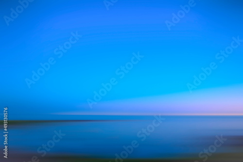 Peaceful beautiful abstract outdoor photograph from beach of horizon with ocean and sky during blue hour with copy space