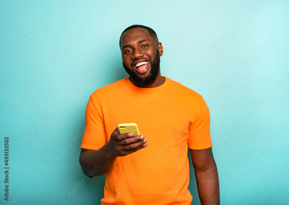 © alphaspirit - Happy man is happy with a yellow mobile phone in hand