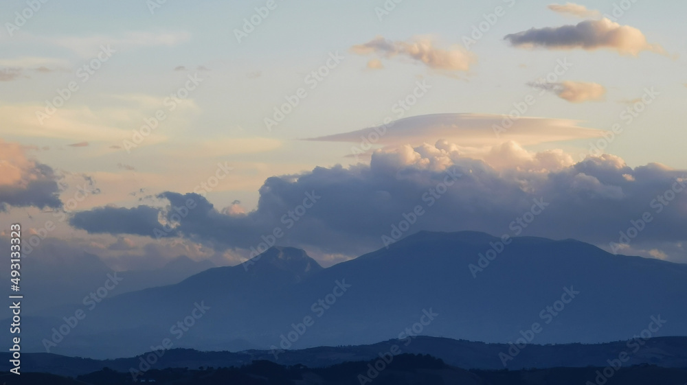 Nuvole bianche sopra la cima dei monti al tramonto