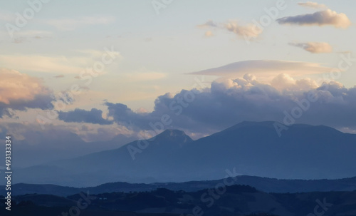 Nuvole bianche sopra la cima dei monti al tramonto © GjGj