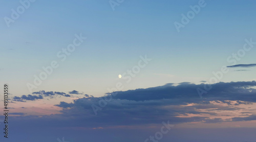 Luna del pomeriggio sopra le nuvole