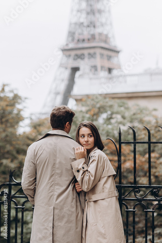 Happy to be together. Rear view of beautiful young couple holding hands and looking at each other with smile while walking through the city street © ALEXSTUDIO