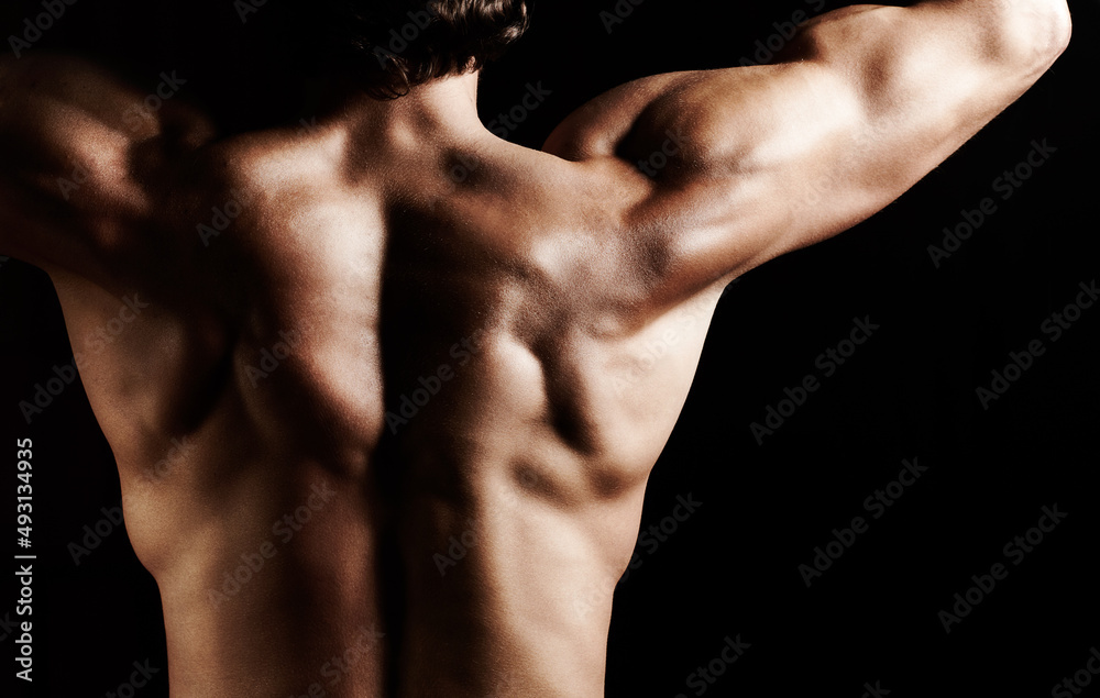 Masculinity in portrait. Studio shot of a muscular shirtless man isolated on black. Masculinity in portrait. Studio shot of a muscular shirtless man isolated on black.