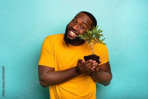 Man holds and takes care of a small tree photo