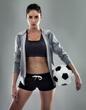 Lets score some goals. Studio shot of a sporty young woman against a gray background.