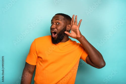 Fotografie Man speaks in the ear to a friend about a great promotion